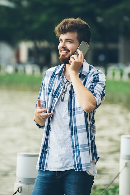 Heureux Homme Parle à Sa Petite Amie Au Téléphone, Debout à L'extérieur