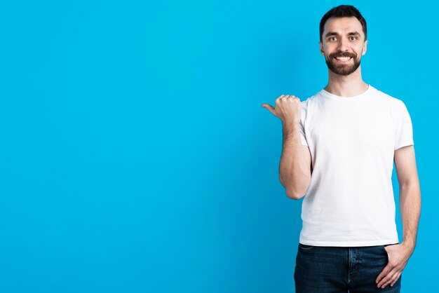 Heureux homme pointant à côté de lui