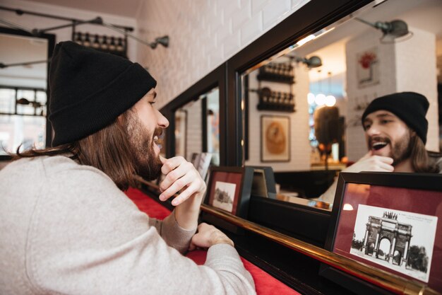 Heureux homme posant près du miroir