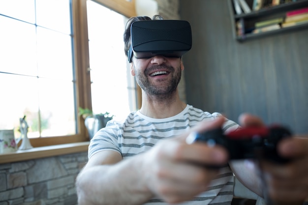 Photo gratuite heureux l'homme utilisant la réalité virtuelle casque et les jeux vidéo