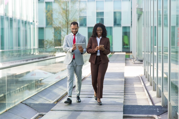 Heureux hommes d'affaires à l'aide de gadgets