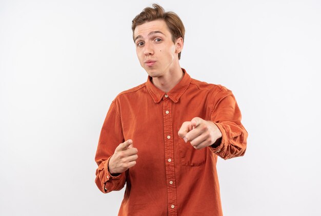 Heureux jeune beau mec portant des points de chemise rouge isolés sur mur blanc