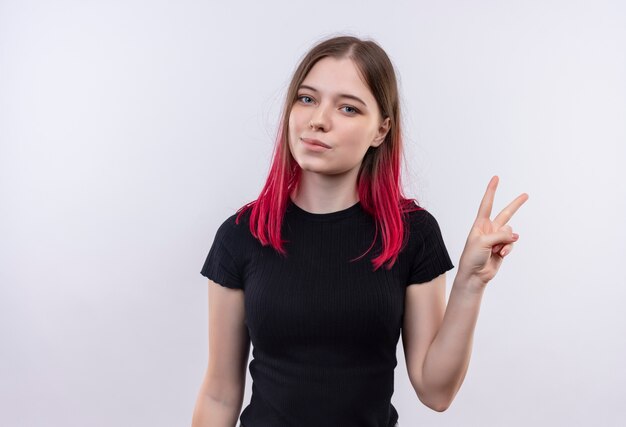 Heureux jeune belle fille portant un t-shirt noir montrant le geste de paix sur fond blanc isolé