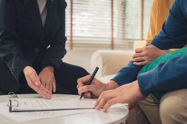 Heureux jeune couple asiatique et agent immobilier