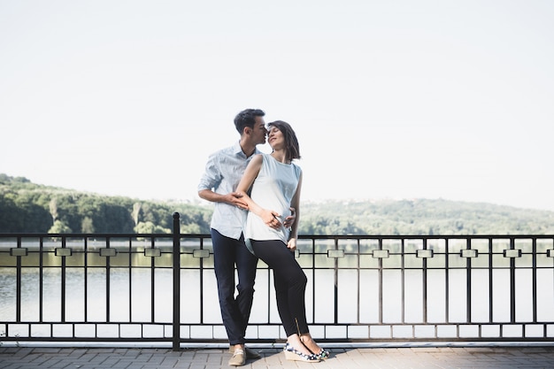 Heureux Et Jeune Couple Enceinte étreignant Dans La Nature Au Bord Du Lac