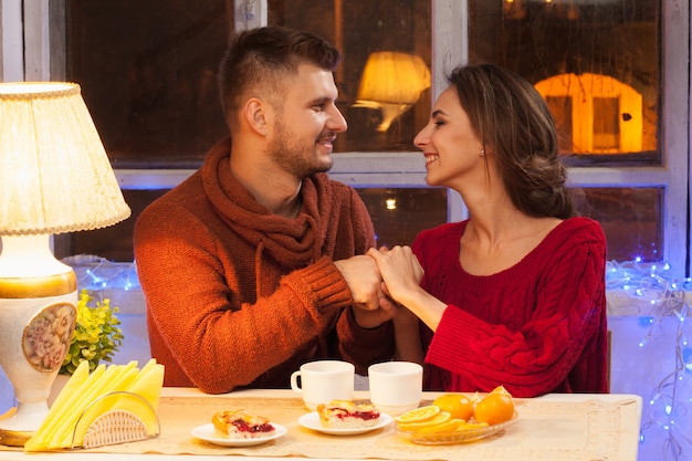 heureux jeune couple avec des tasses de thé