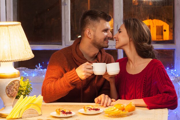 heureux jeune couple avec des tasses de thé