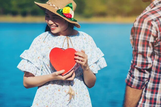 Heureux jeune couple tient des coeurs de papier rouge