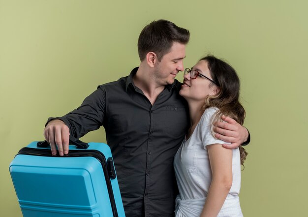 Heureux Jeune Couple De Touristes Homme Et Femme Tenant Une Valise En Regardant Les Uns Les Autres étreindre La Lumière