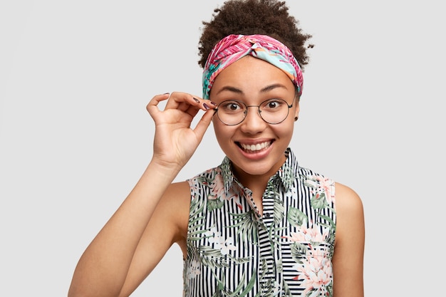 Heureux jeune femme afro-américaine à lunettes, sourit doucement