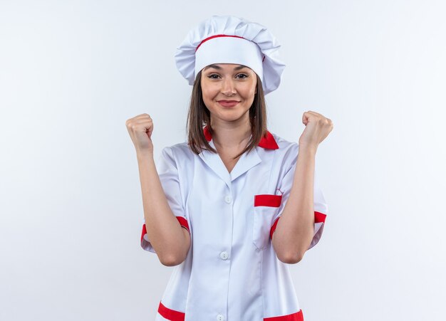 heureux jeune femme cuisinier portant l'uniforme de chef montrant oui geste isolé sur mur blanc