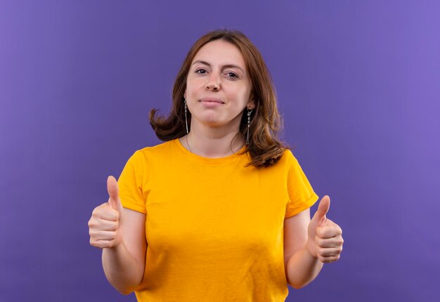 Heureux jeune femme décontractée montrant les pouces vers le haut sur l'espace violet isolé