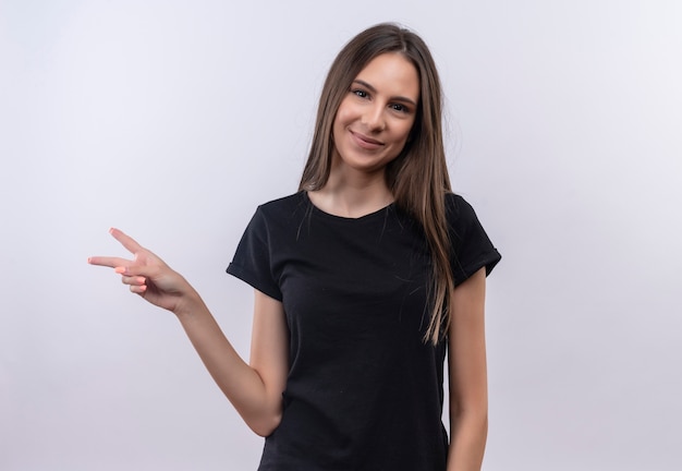 Heureux jeune fille de race blanche portant un t-shirt noir montrant le geste de paix sur fond blanc isolé