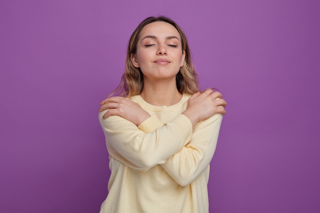 Heureux jeune fille s'embrassant les yeux fermés