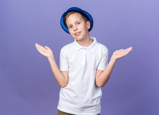 Heureux Jeune Garçon Slave Avec Chapeau De Fête Bleu Gardant Les Mains Ouvertes Isolé Sur Mur Violet Avec Espace Copie