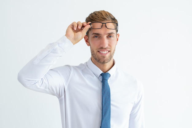 Heureux jeune homme d&#39;affaires élever des lunettes