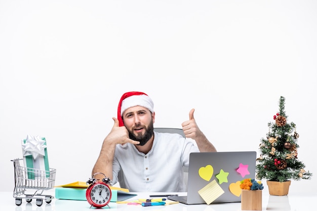 Heureux jeune homme d'affaires positif avec un chapeau de père Noël travaillant