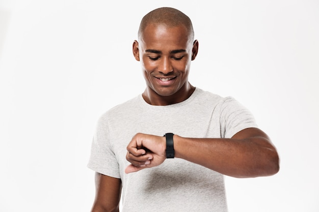 Heureux jeune homme africain à l'aide de la montre.