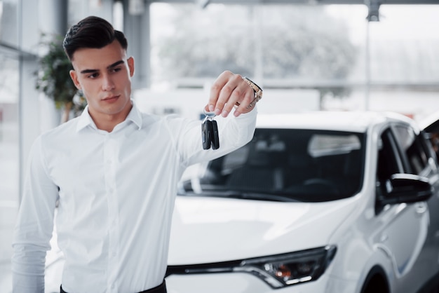 Heureux jeune homme avec des clés dans ses mains, chanceux acheter une voiture