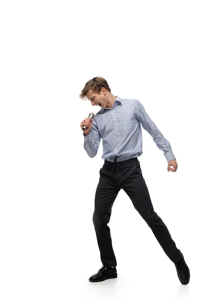 Heureux jeune homme dansant dans des vêtements décontractés ou un costume, refaisant des mouvements légendaires de célébrités de l'histoire de la culture