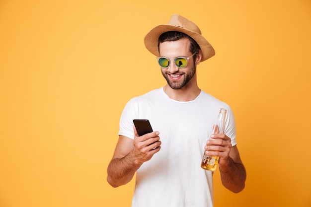 Heureux jeune homme debout isolé sur mur jaune