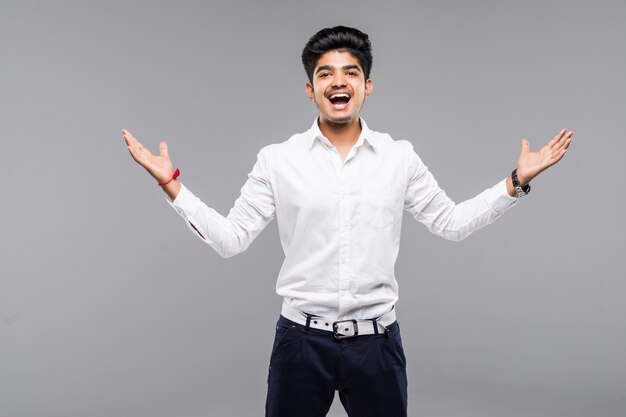 Heureux jeune homme indien célébrant la victoire sur le mur gris