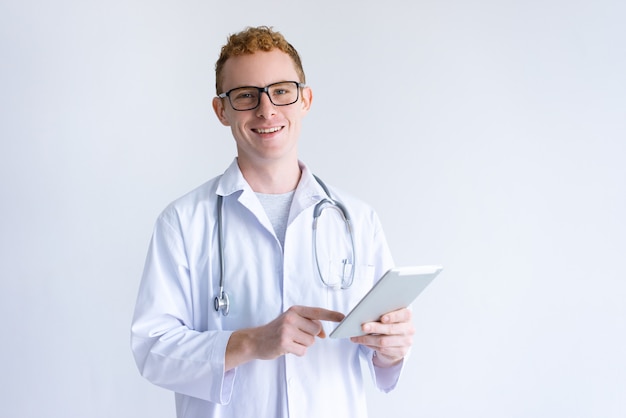 Heureux jeune homme médecin à l&#39;aide d&#39;une tablette