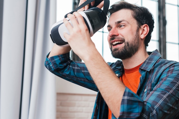 Photo gratuite heureux jeune homme portant des lunettes de réalité virtuelle