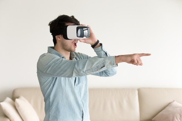 Heureux jeune homme en réalité virtuelle portant VR headse