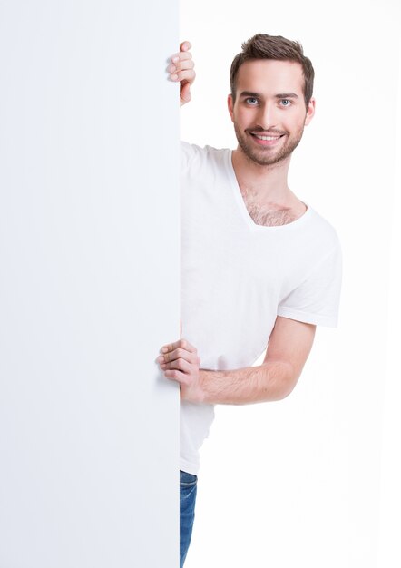 Heureux jeune homme regarde de la bannière vierge - isolé sur blanc