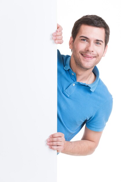 Heureux jeune homme regarde de la bannière vierge - isolé sur blanc.