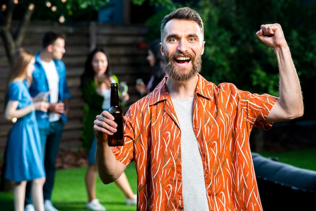 Heureux jeune homme tenant une bière