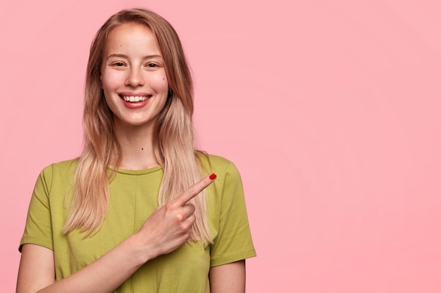 Heureux jeune modèle féminin à la recherche agréable sourit joyeusement