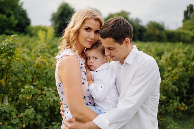 Heureux jeune papa de famille, maman et petit fils a l'air heureux dans le parc