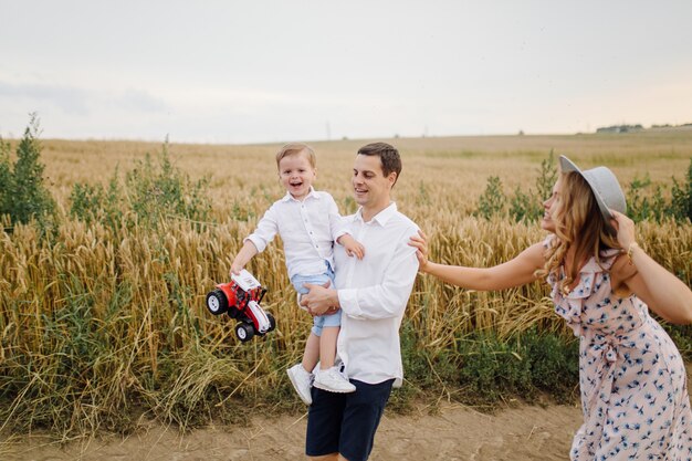 Heureux jeune papa de famille, maman et petit fils a l'air heureux dans le parc