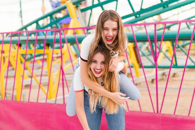 Heureux jeunes amis dans le parc d&#39;attractions