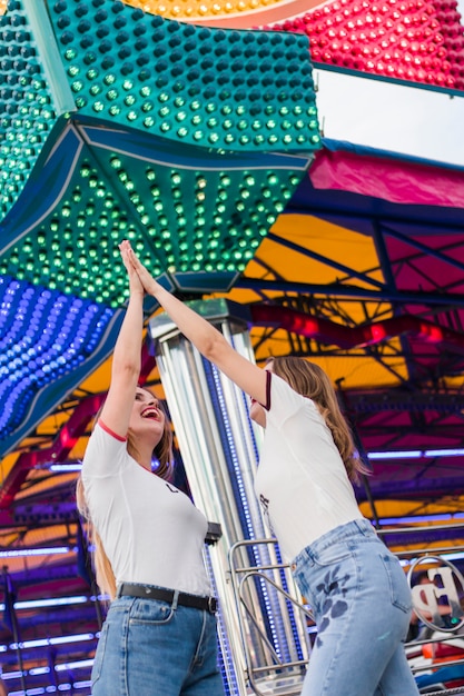 Photo gratuite heureux jeunes amis dans le parc d'attractions