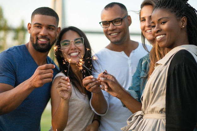 Heureux jeunes amis avec des feux de Bengale