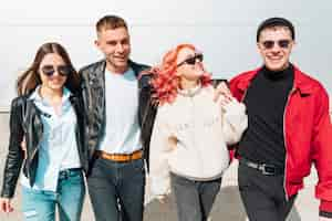 Photo gratuite heureux jeunes amis marchant dans la rue