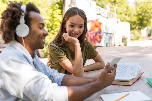 Photo gratuite heureux jeunes amis multiethniques étudiants discutant entre eux