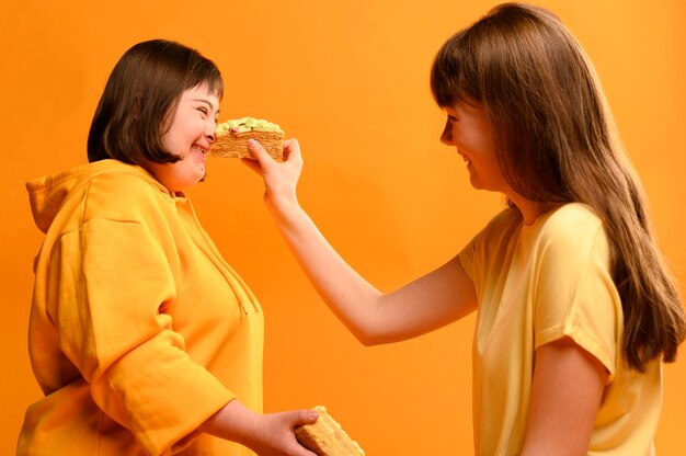 Photo gratuite heureux jeunes filles jouant avec un gâteau