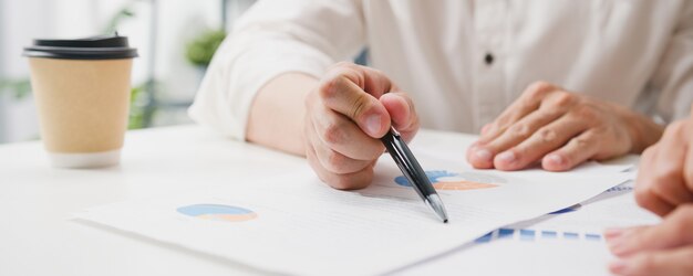 Heureux jeunes hommes d'affaires et femmes d'affaires d'Asie rencontrant des idées de remue-méninges sur de nouveaux collègues du projet de paperasse travaillant ensemble