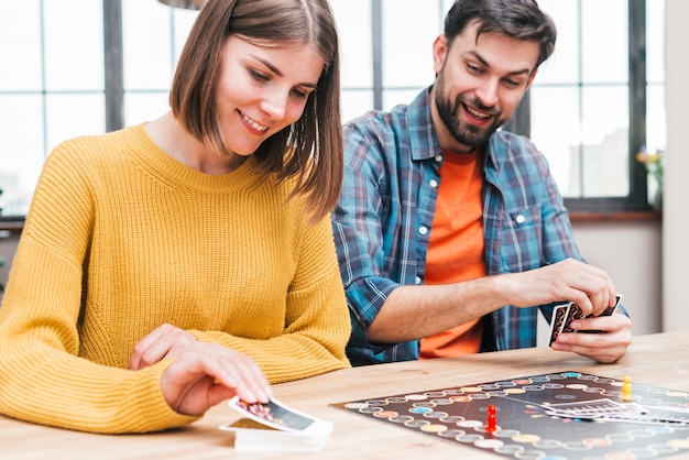 Photo gratuite heureux mari et femme jouant au jeu de cartes de visite