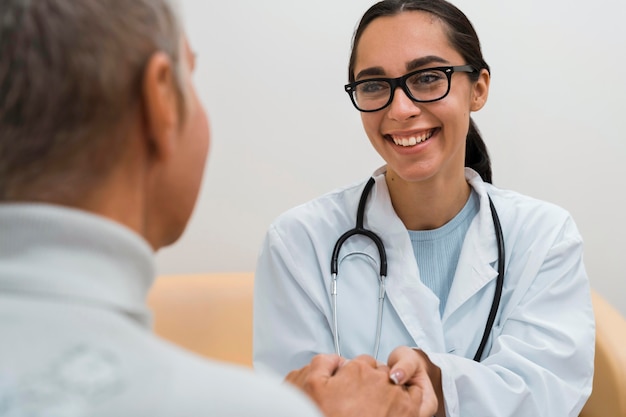 Heureux médecin parlant à un patient