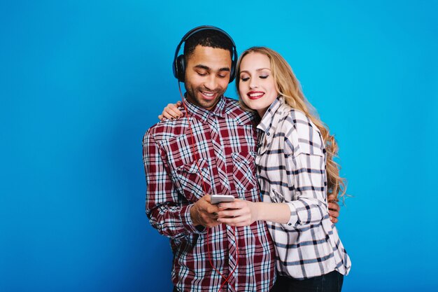 Heureux moments de couple joyeux en écoutant de la musique. S'amuser, utiliser le téléphone, passe-temps, week-ends, temps libre, écouter des chansons, exprimer la positivité, sourire, amoureux.