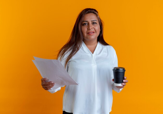 Heureux occasionnel caucasien femme d'âge moyen tenant du papier et une tasse de café