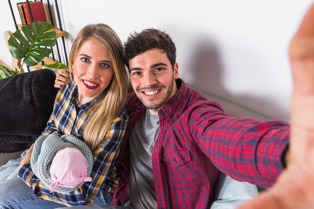 Heureux parents prenant selfie avec bébé