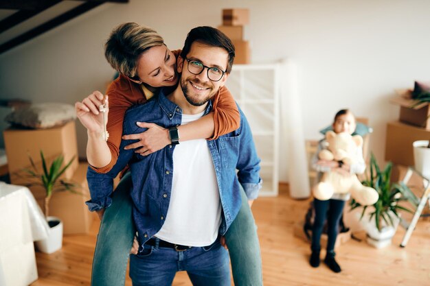 Heureux parents s'amusant en emménageant dans une nouvelle maison avec leur fille