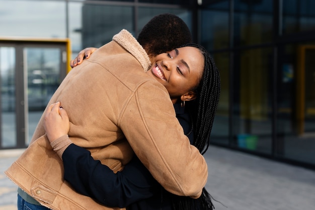 Photo gratuite heureux partenaires étreignant plan moyen