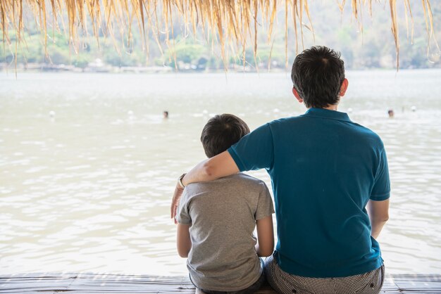 Heureux père et fils pendant des vacances à la nature du site de l'eau